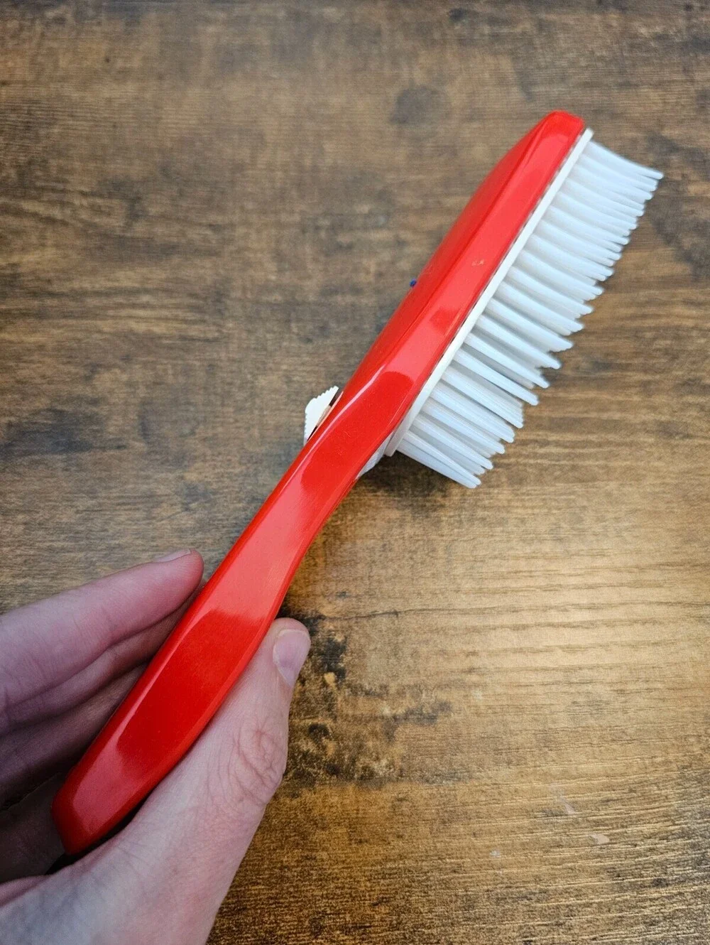 Vintage 1970s hair brush with a red handle and flexible white bristles